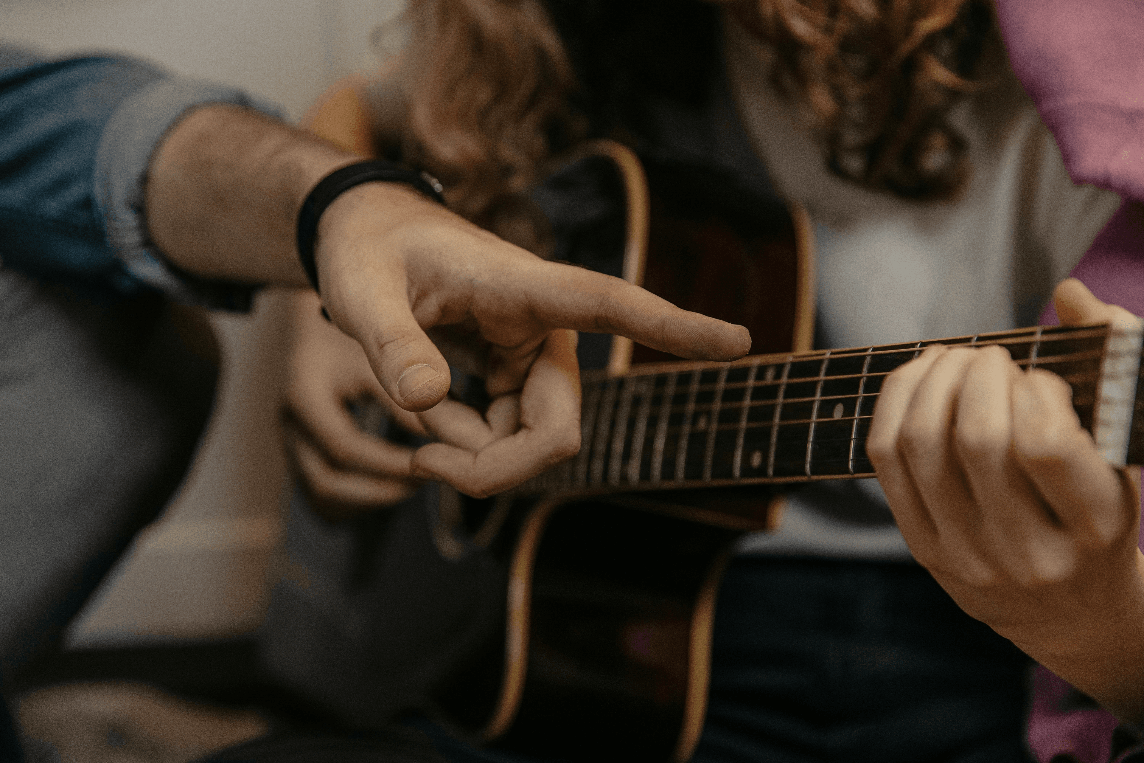 Person demonstrating proper finger placement on a guitar